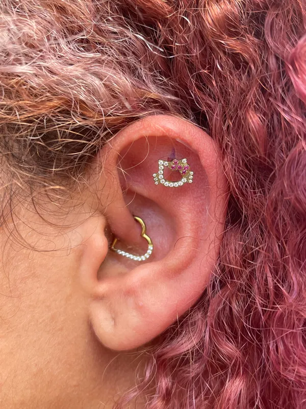 Piercings flat e daith na orelha com joias em titânio, feitos no Lonely Hearts Club Tattoo, Torres Vedras